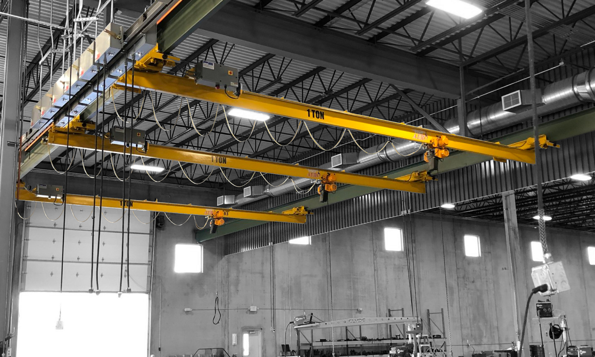 interior of a ware house with multiple yellow ceiling crane beams - Aero Material Handling Inc