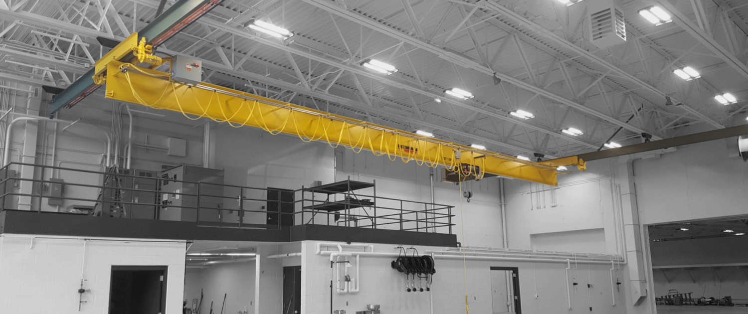 interior of a ware house with multiple yellow ceiling crane beams - Aero Material Handling Inc