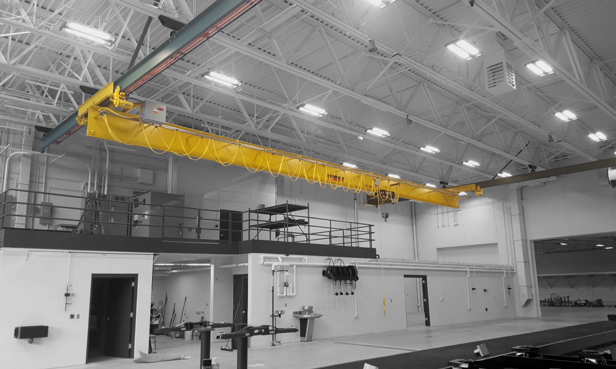 interior of a ware house with multiple yellow ceiling crane beams - Aero Material Handling Inc