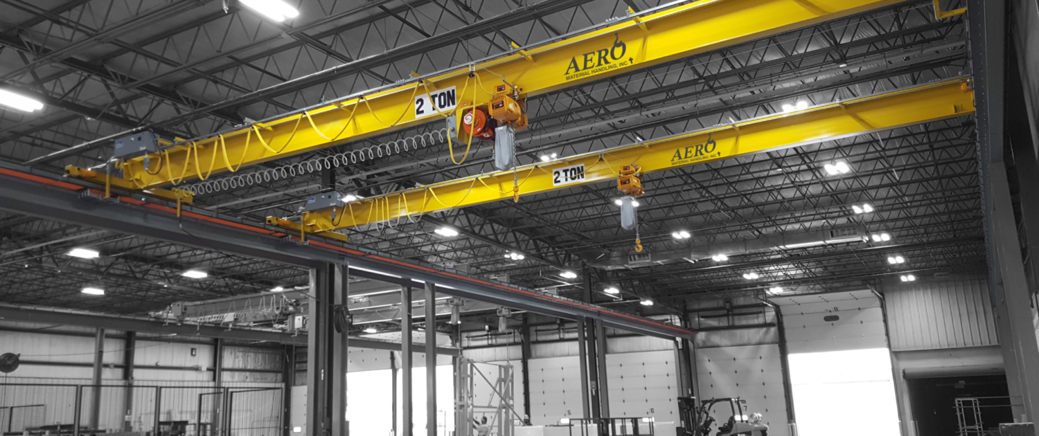 interior of a ware house with multiple yellow ceiling crane beams - Aero Material Handling Inc