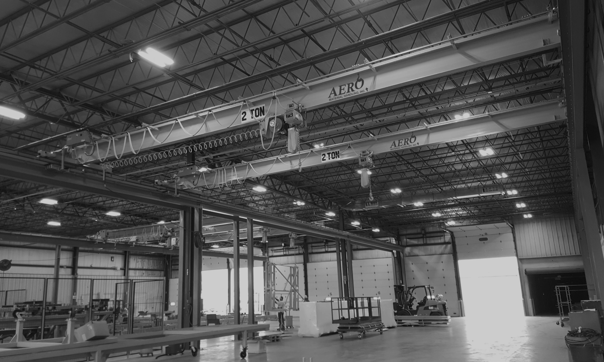 interior of a ware house with multiple yellow ceiling crane beams - Aero Material Handling Inc