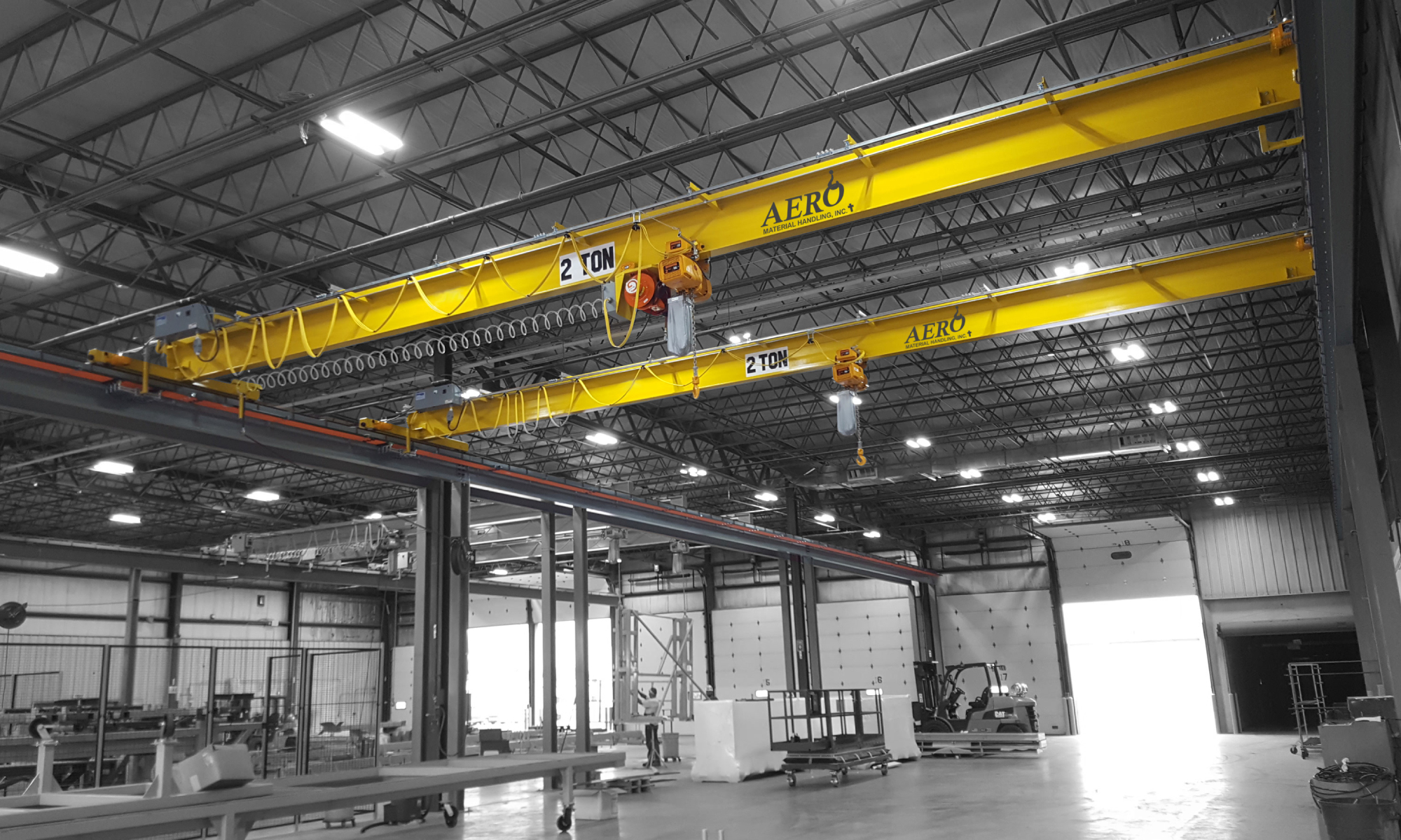 interior of a ware house with multiple yellow ceiling crane beams - Aero Material Handling Inc