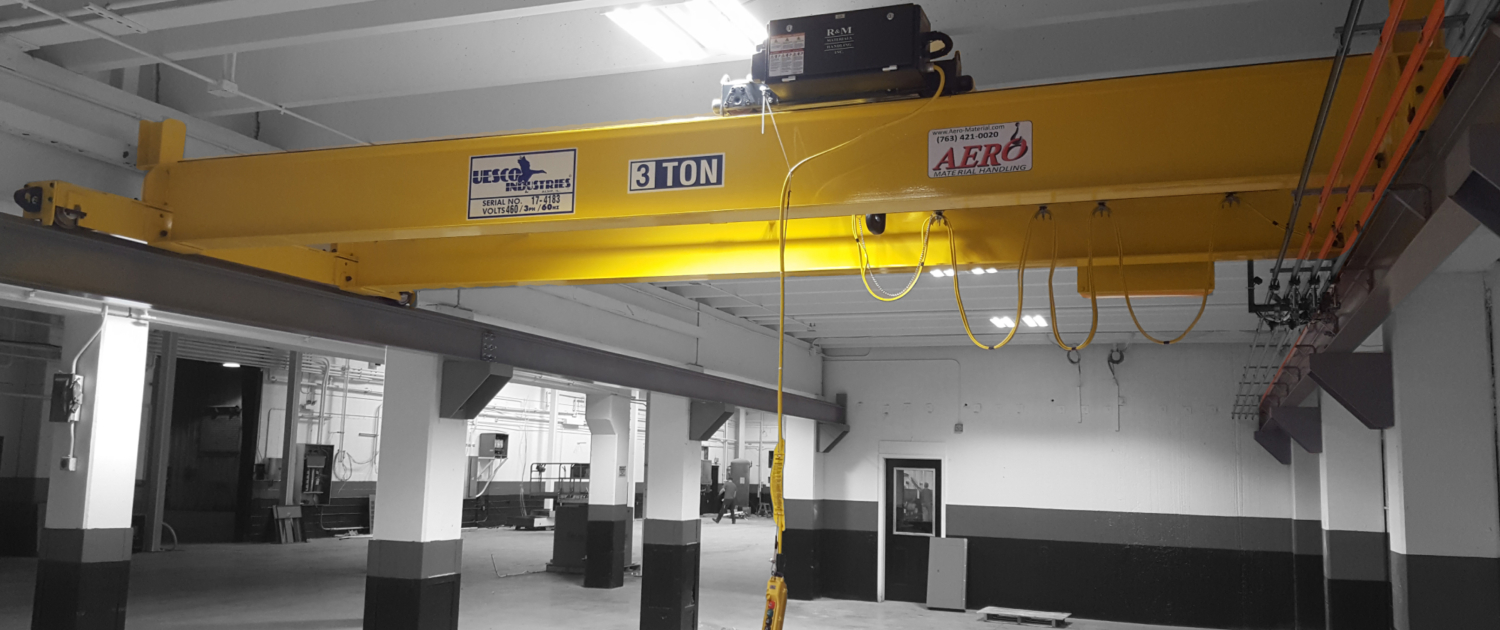 interior of a ware house with multiple yellow ceiling crane beams - Aero Material Handling Inc