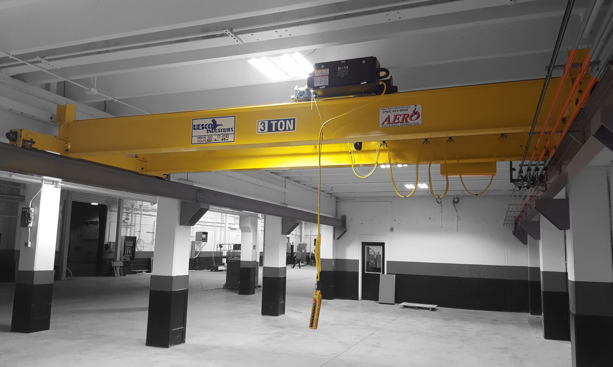 interior of a ware house with multiple yellow ceiling crane beams - Aero Material Handling Inc