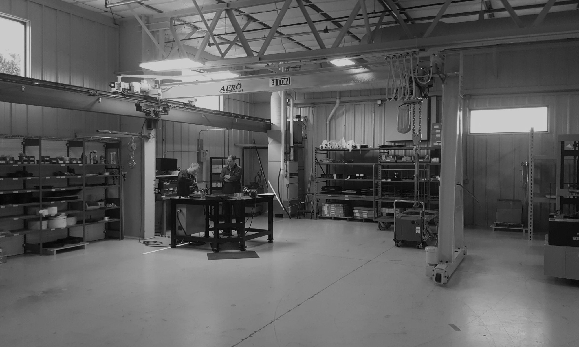 interior of a ware house with multiple yellow ceiling crane beams - Aero Material Handling Inc