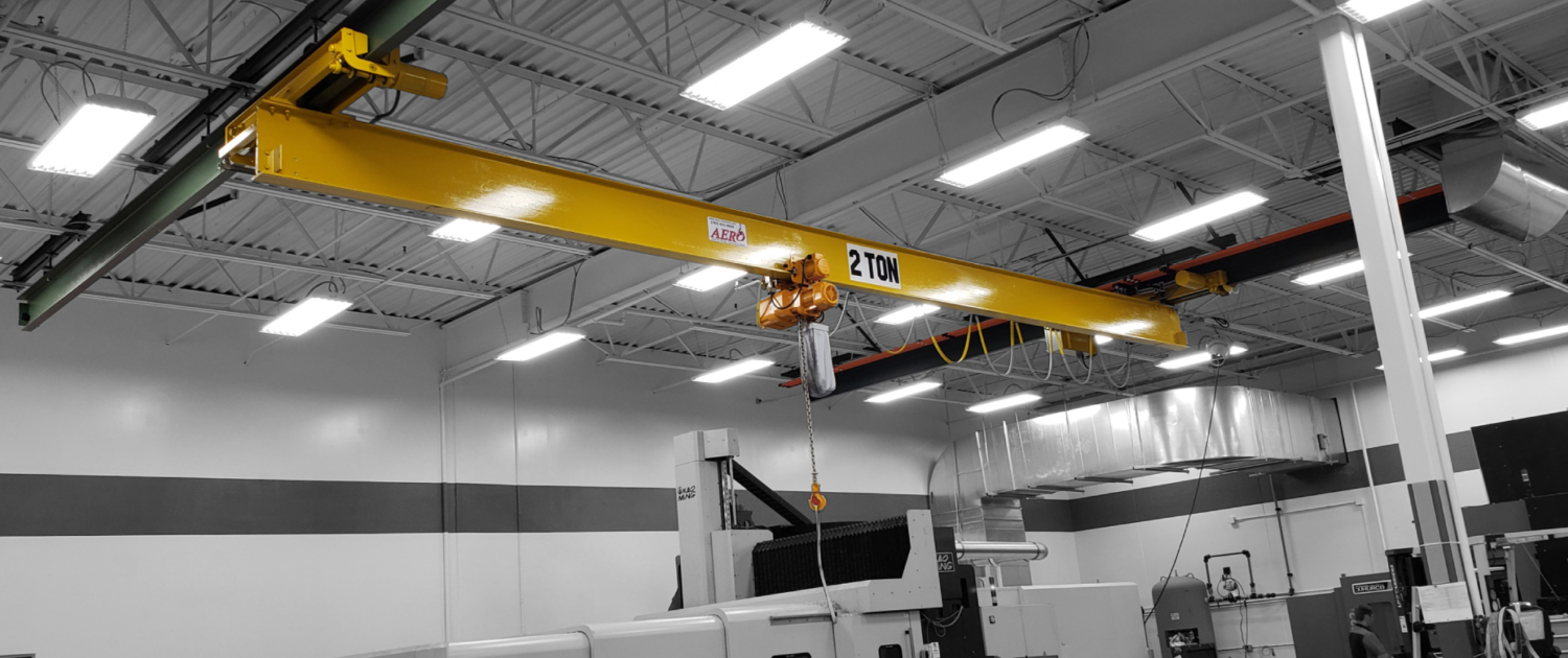 interior of a ware house with multiple yellow ceiling crane beams - Aero Material Handling Inc