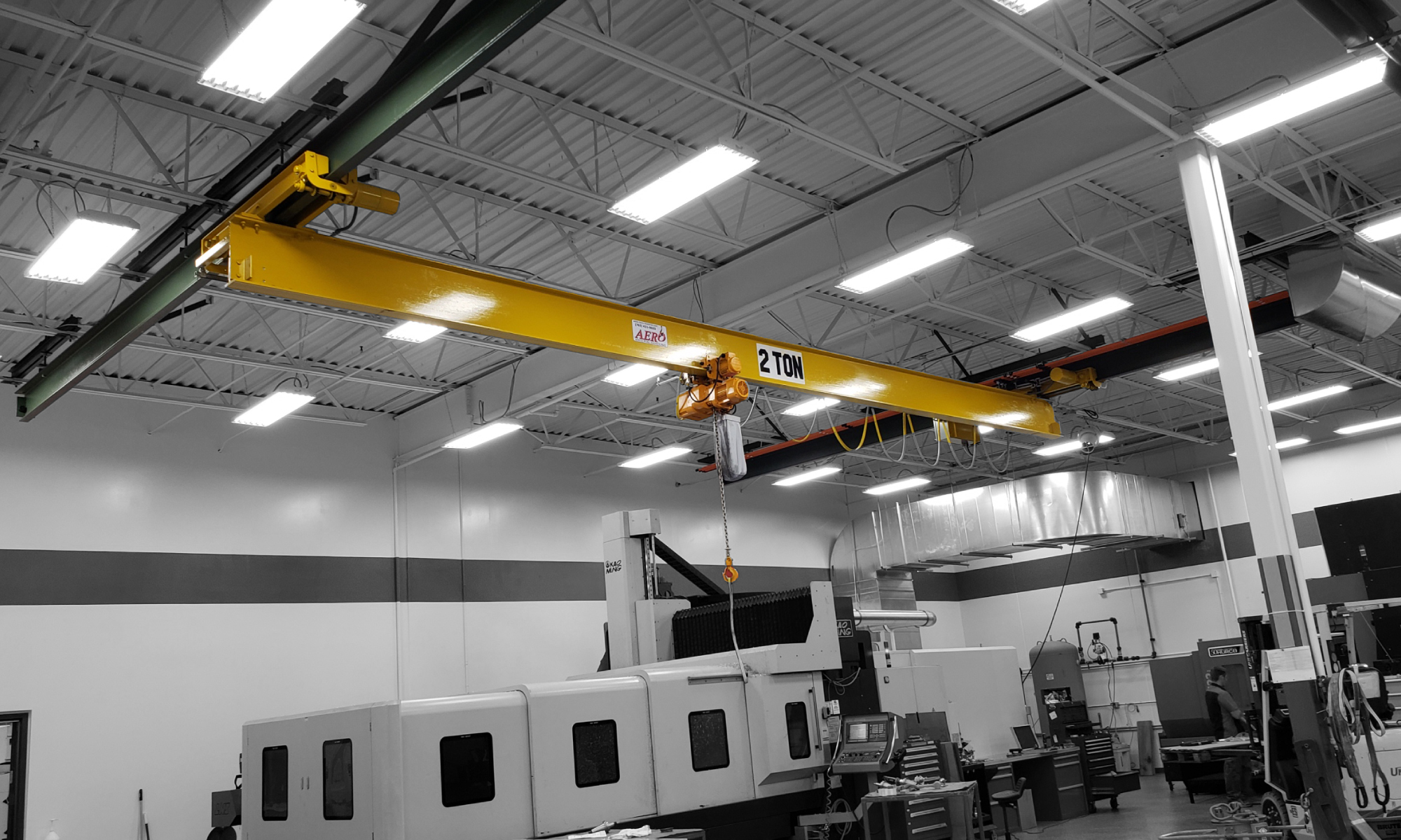 interior of a ware house with multiple yellow ceiling crane beams - Aero Material Handling Inc