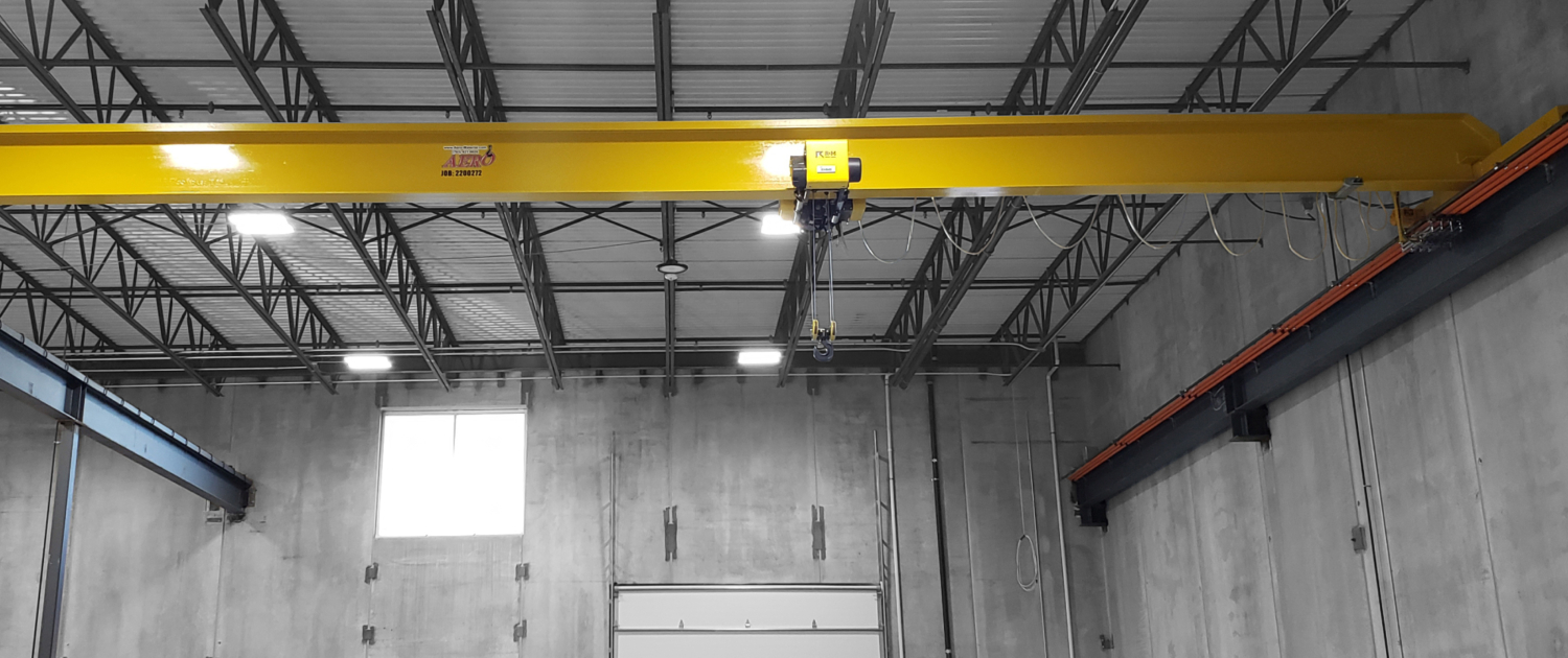 interior of a ware house with multiple yellow ceiling crane beams - Aero Material Handling Inc