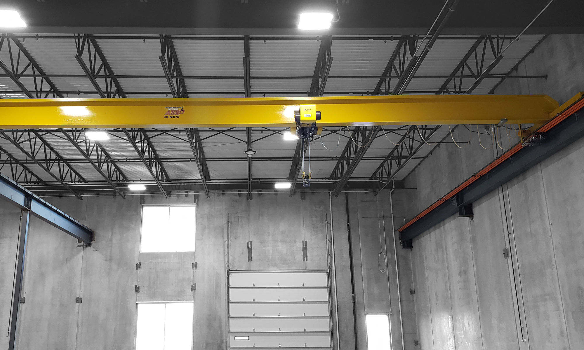 interior of a ware house with multiple yellow ceiling crane beams - Aero Material Handling Inc
