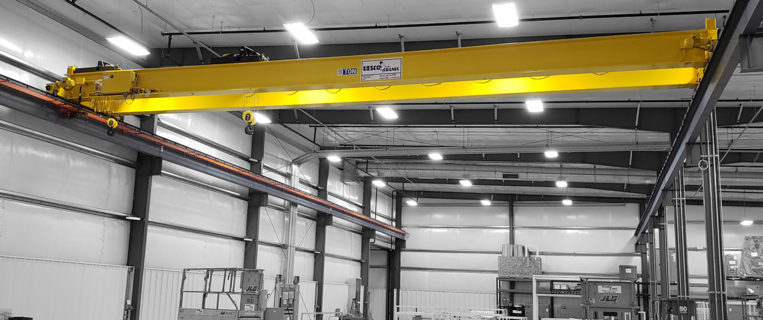 interior of a ware house with multiple yellow ceiling crane beams - Aero Material Handling Inc