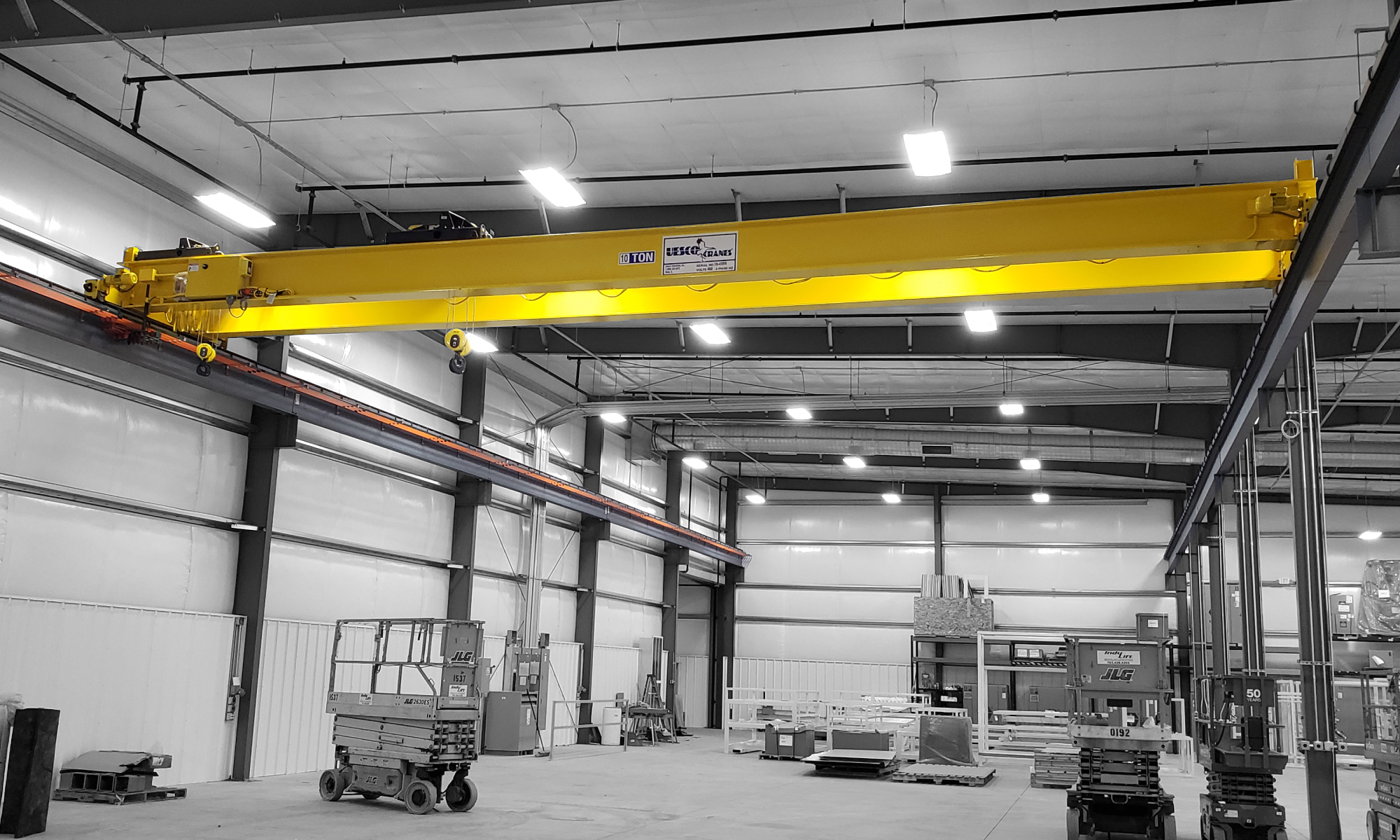 interior of a ware house with multiple yellow ceiling crane beams - Aero Material Handling Inc