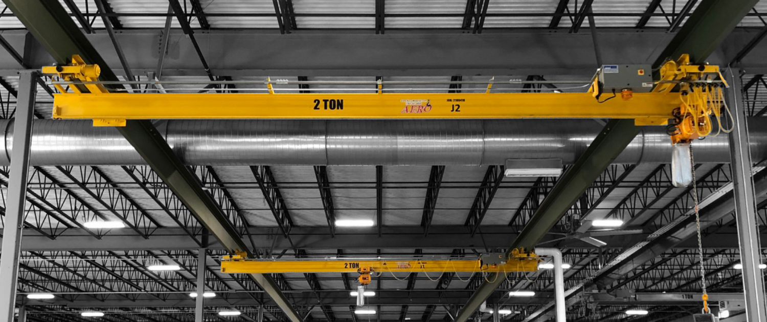 interior of a ware house with multiple yellow ceiling crane beams - Aero Material Handling Inc