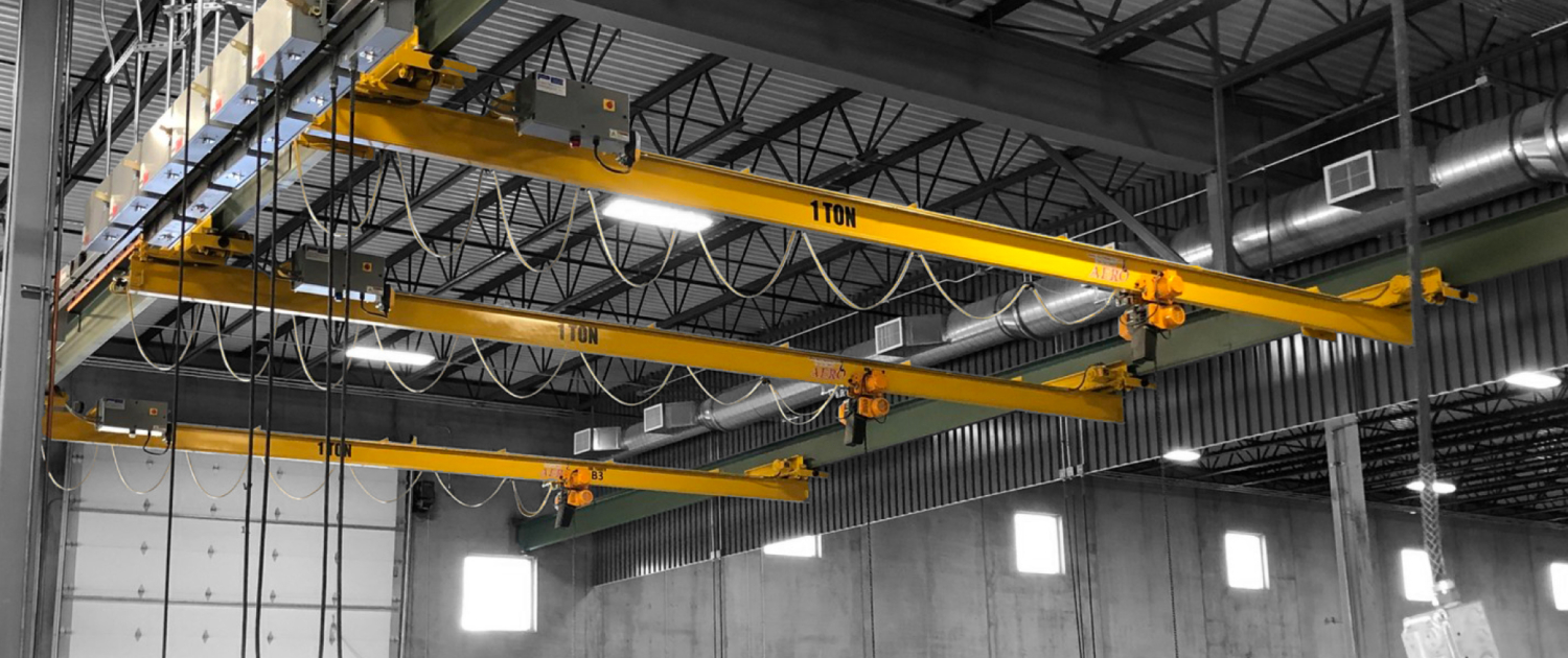 interior of a ware house with multiple yellow ceiling crane beams - Aero Material Handling Inc