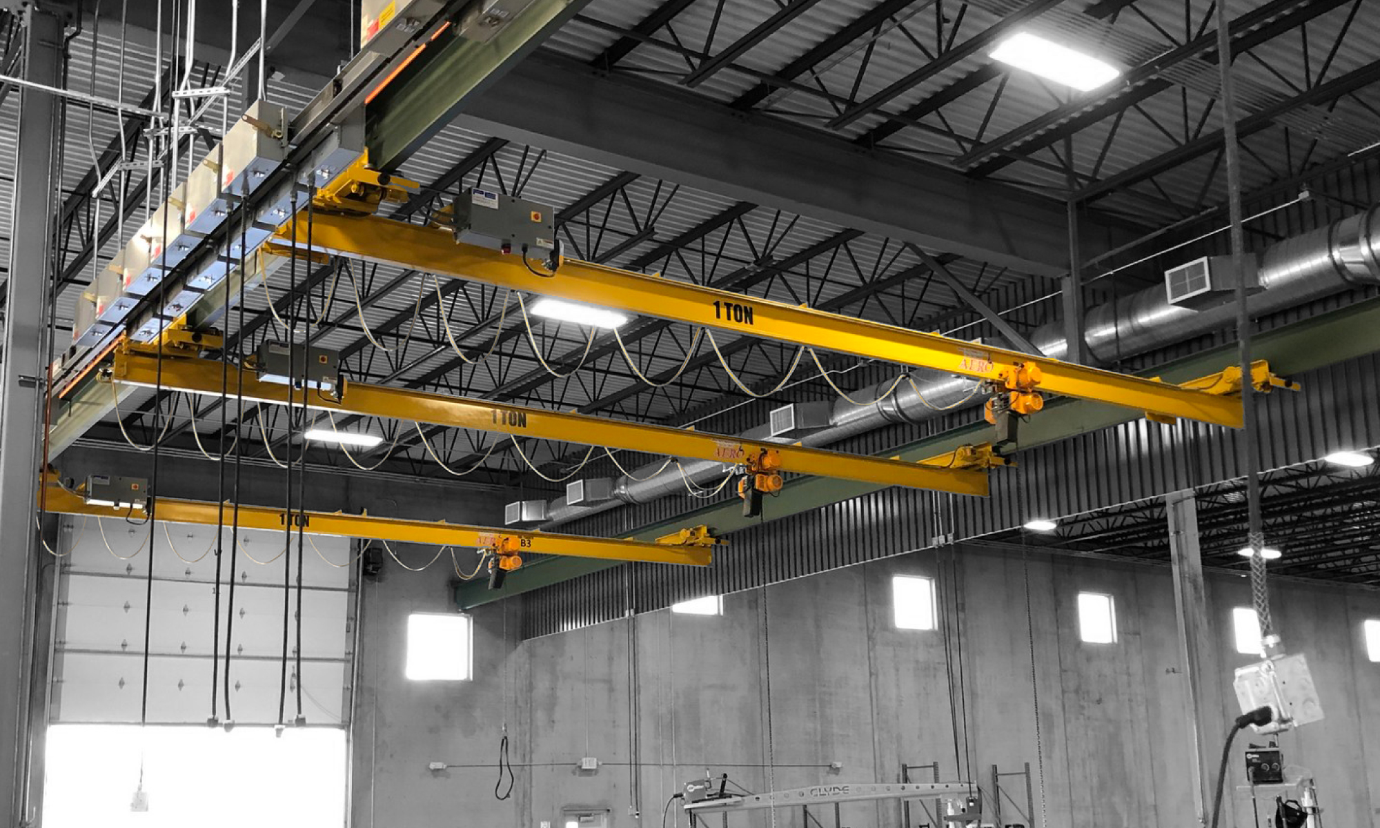 interior of a ware house with multiple yellow ceiling crane beams - Aero Material Handling Inc