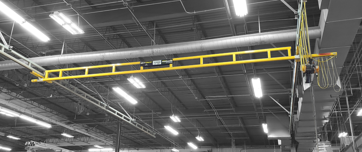 interior of a ware house with multiple yellow ceiling crane beams - Aero Material Handling Inc