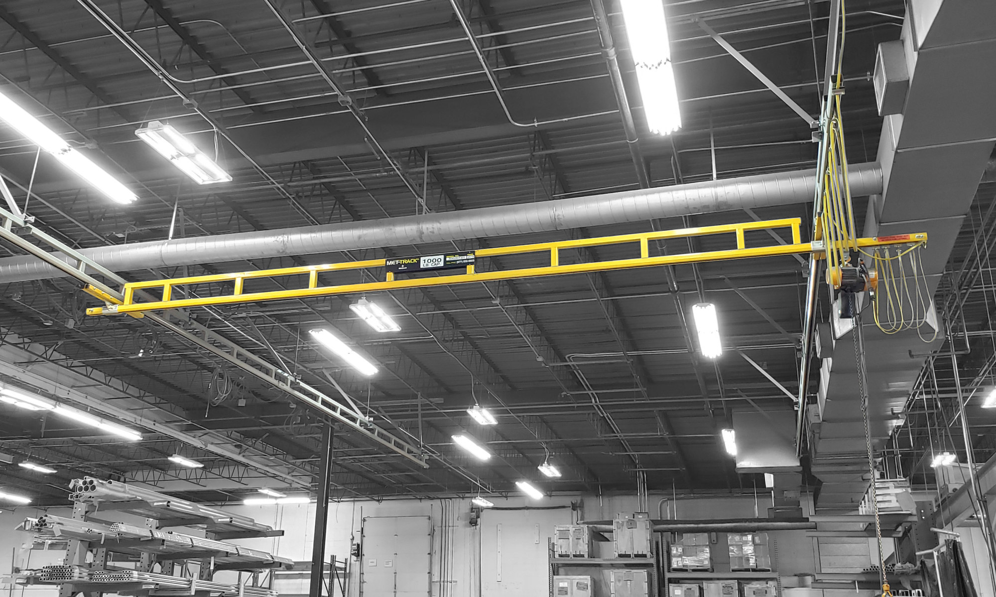 interior of a ware house with multiple yellow ceiling crane beams - Aero Material Handling Inc