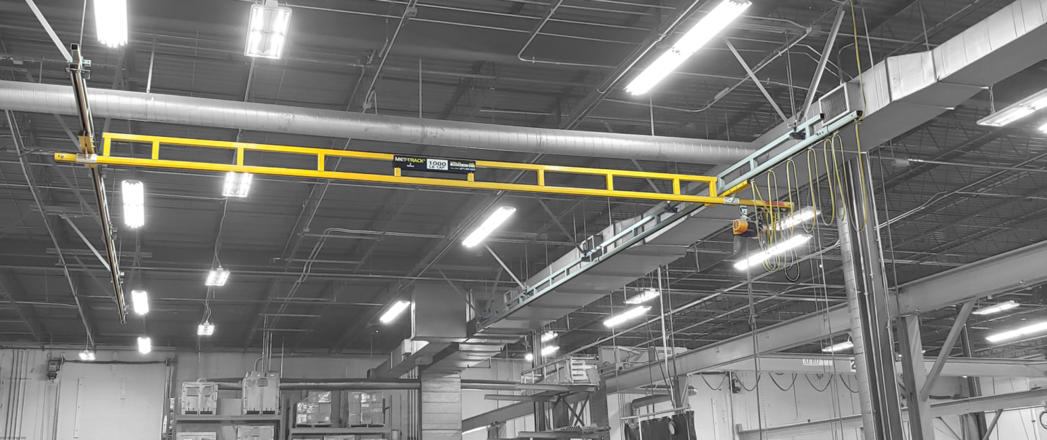 interior of a ware house with multiple yellow ceiling crane beams - Aero Material Handling Inc