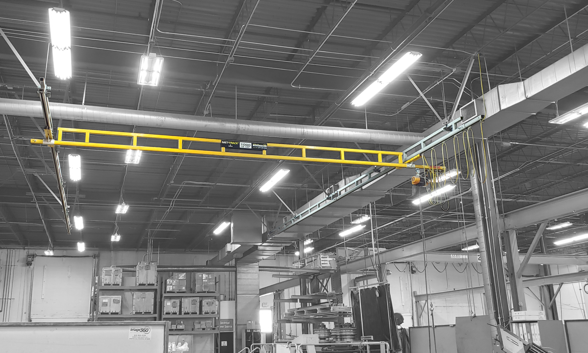 interior of a ware house with multiple yellow ceiling crane beams - Aero Material Handling Inc