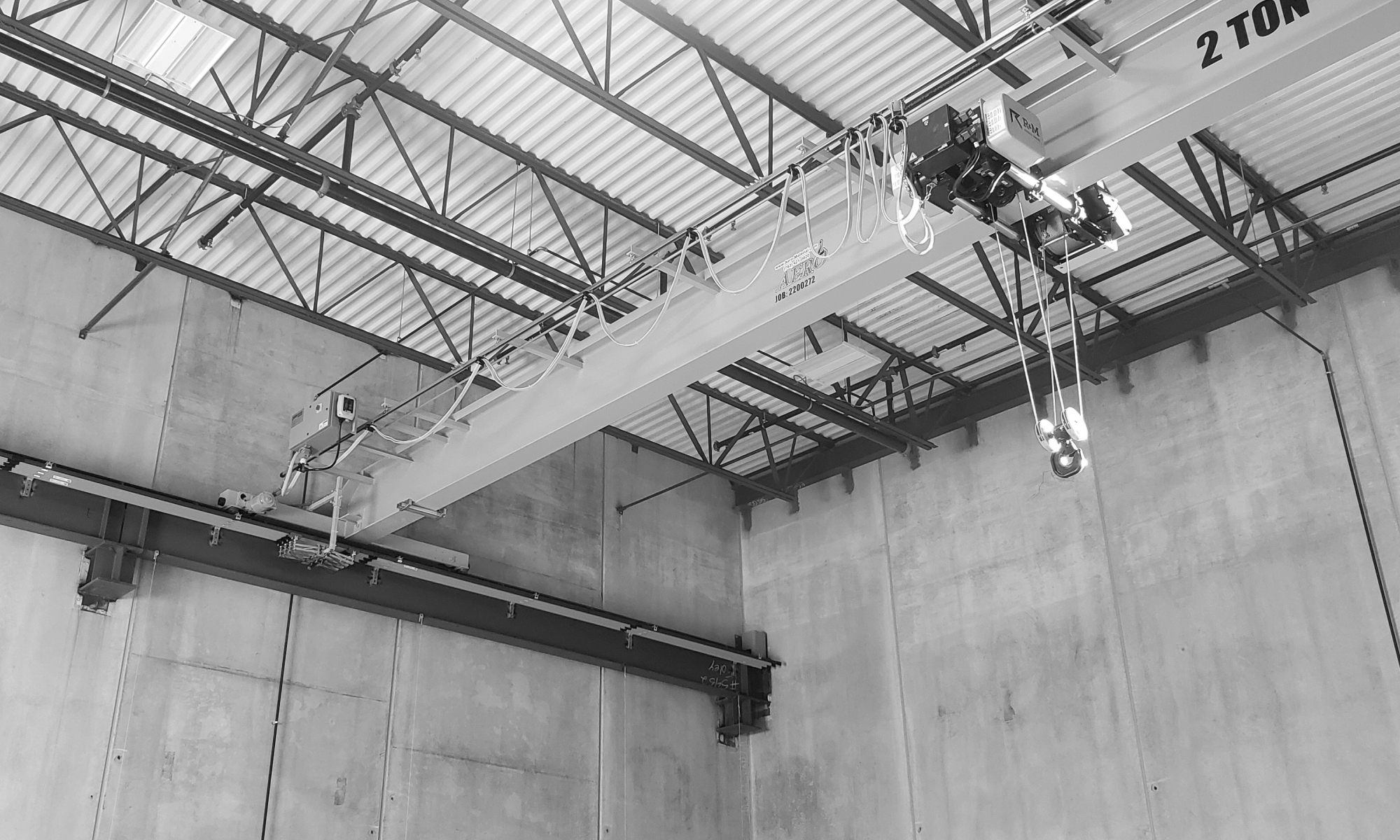 interior of a ware house with multiple yellow ceiling crane beams - Aero Material Handling Inc