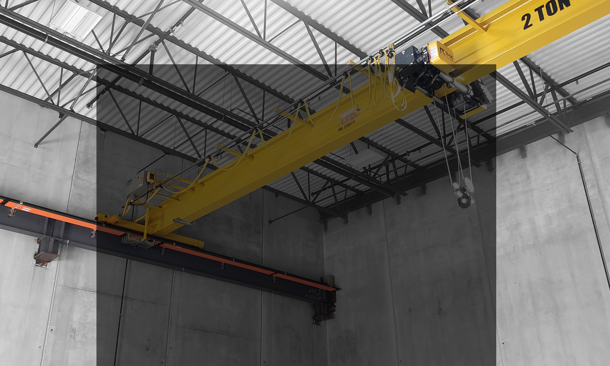 interior of a ware house with multiple yellow ceiling crane beams - Aero Material Handling Inc