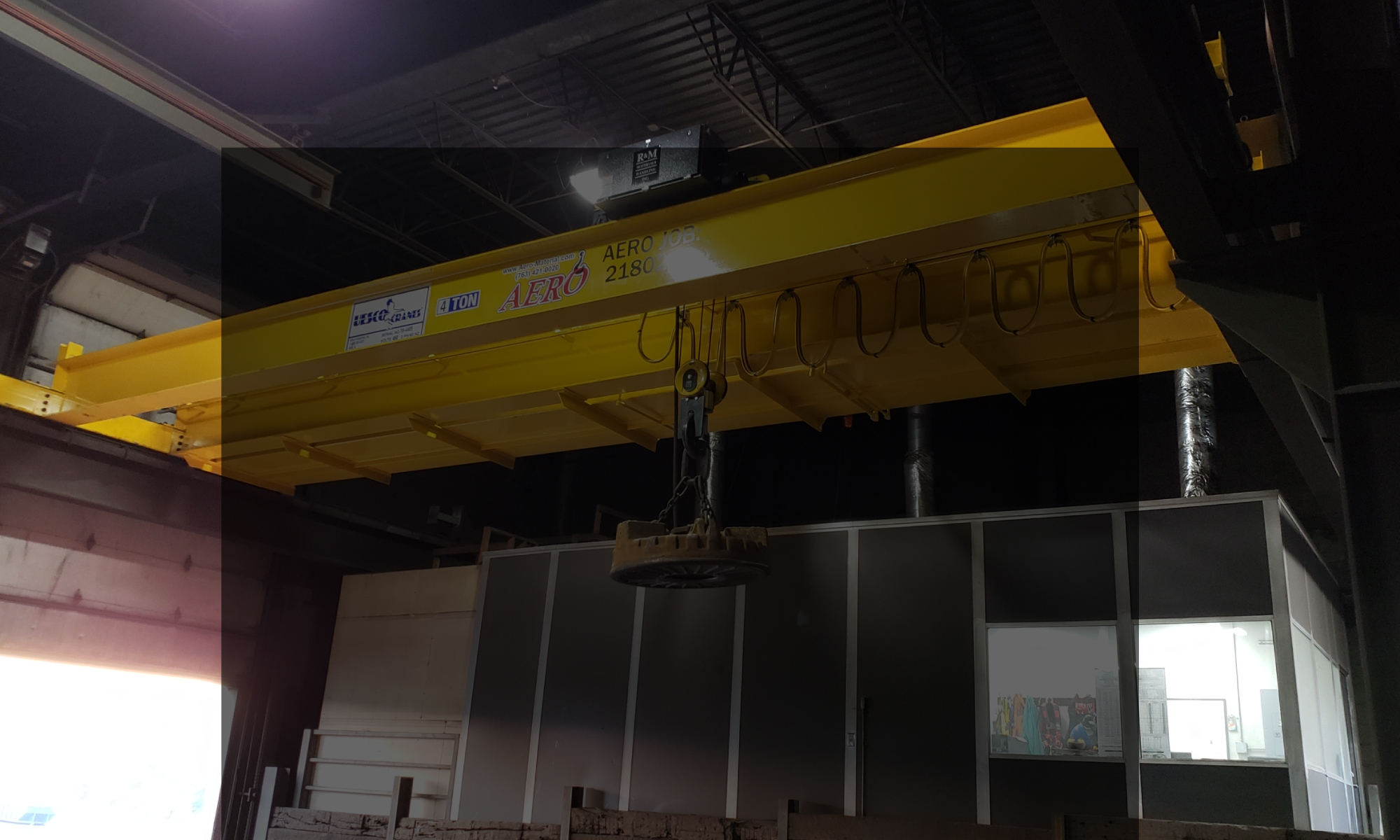 interior of a ware house with multiple yellow ceiling crane beams - Aero Material Handling Inc