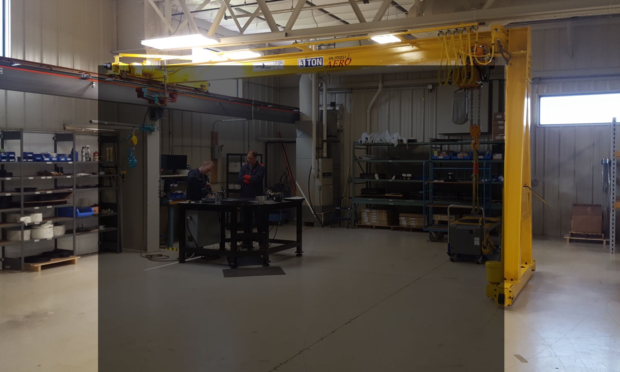 interior of a ware house with multiple yellow ceiling crane beams - Aero Material Handling Inc