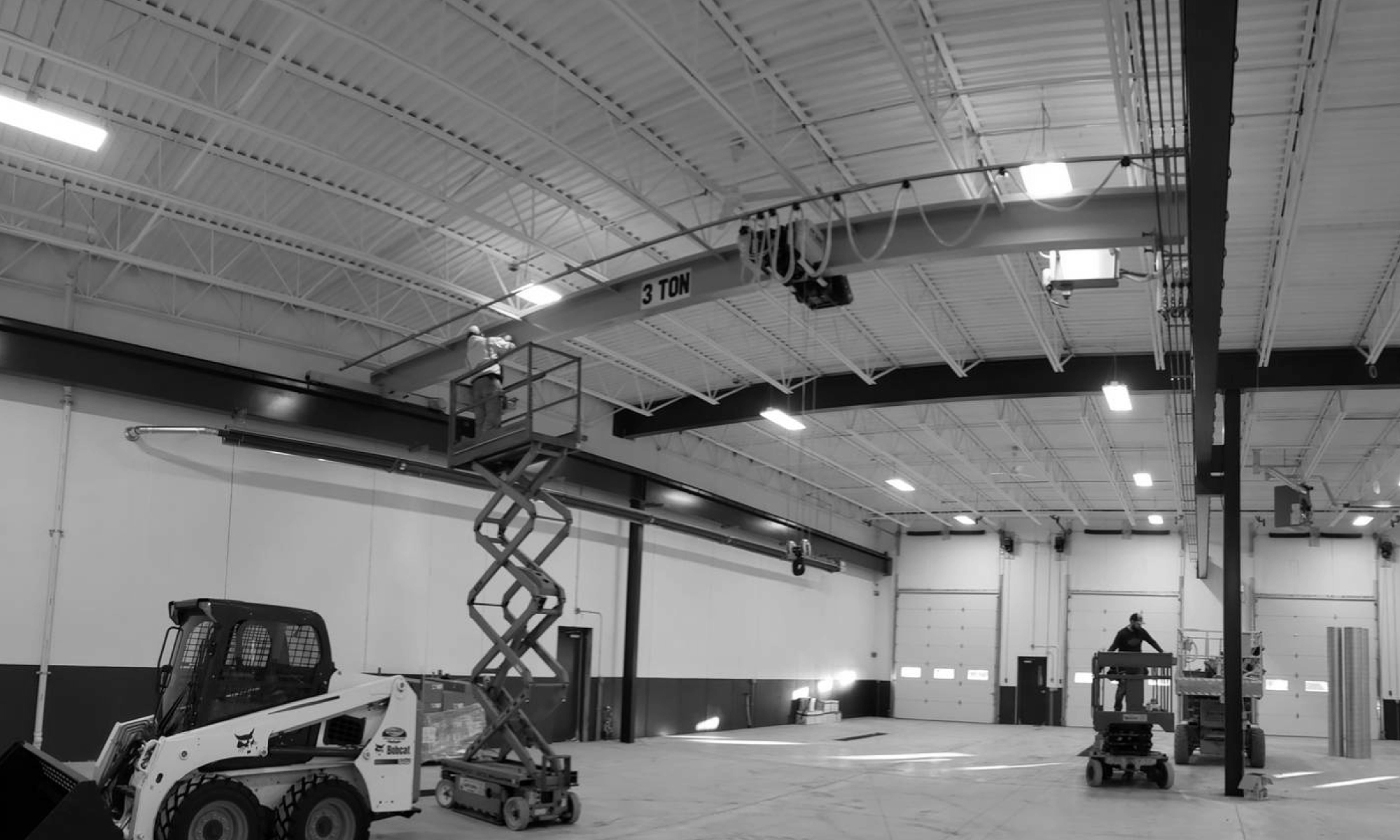 interior of a ware house with multiple yellow ceiling crane beams - Aero Material Handling Inc