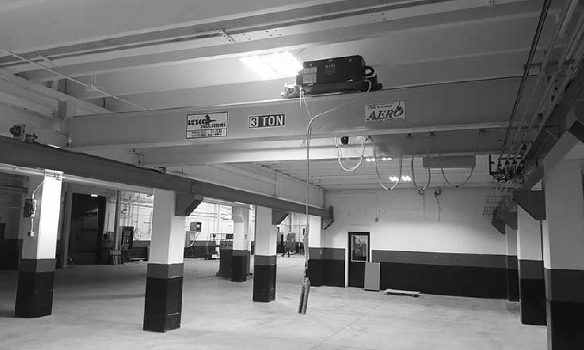 interior of a ware house with multiple yellow ceiling crane beams - Aero Material Handling Inc