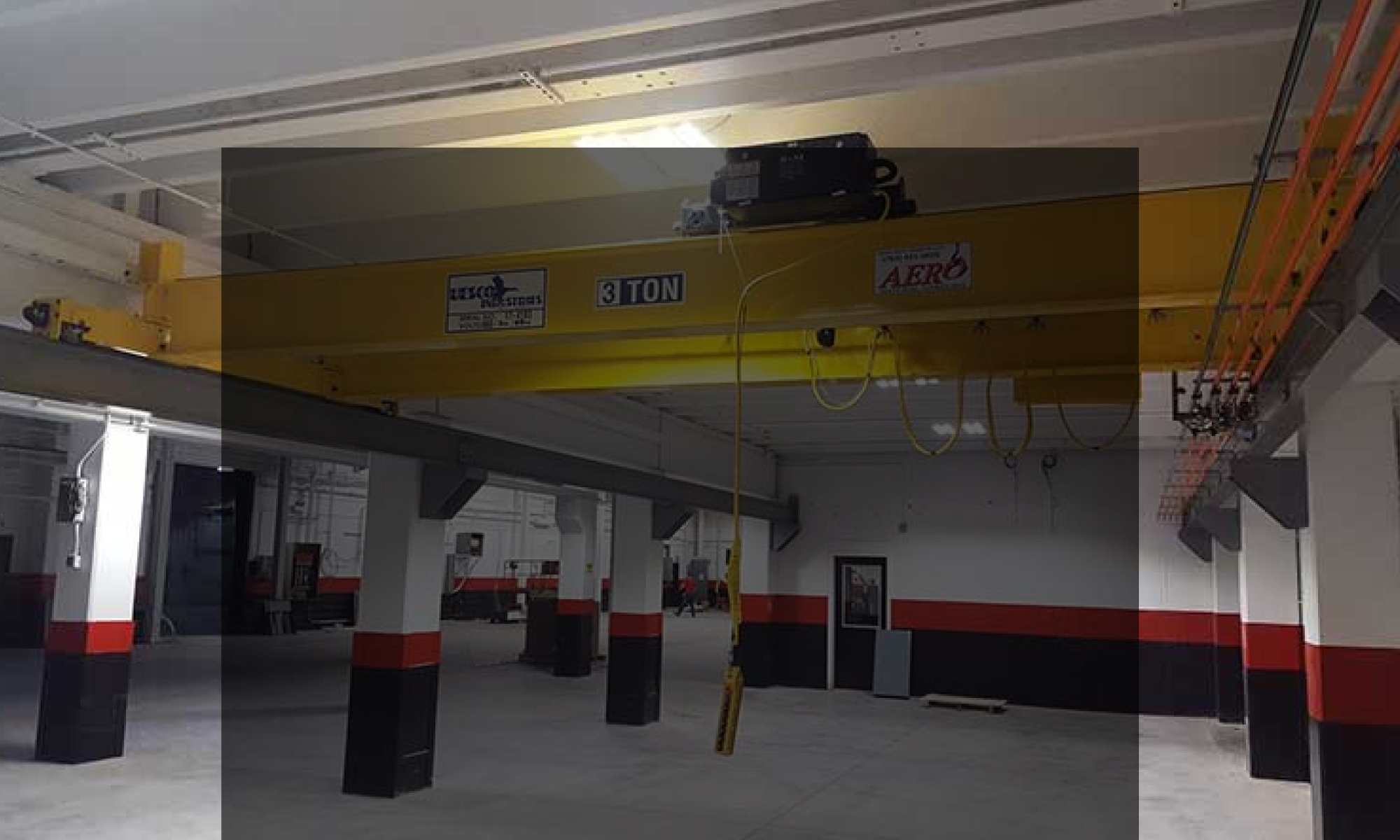 interior of a ware house with multiple yellow ceiling crane beams - Aero Material Handling Inc