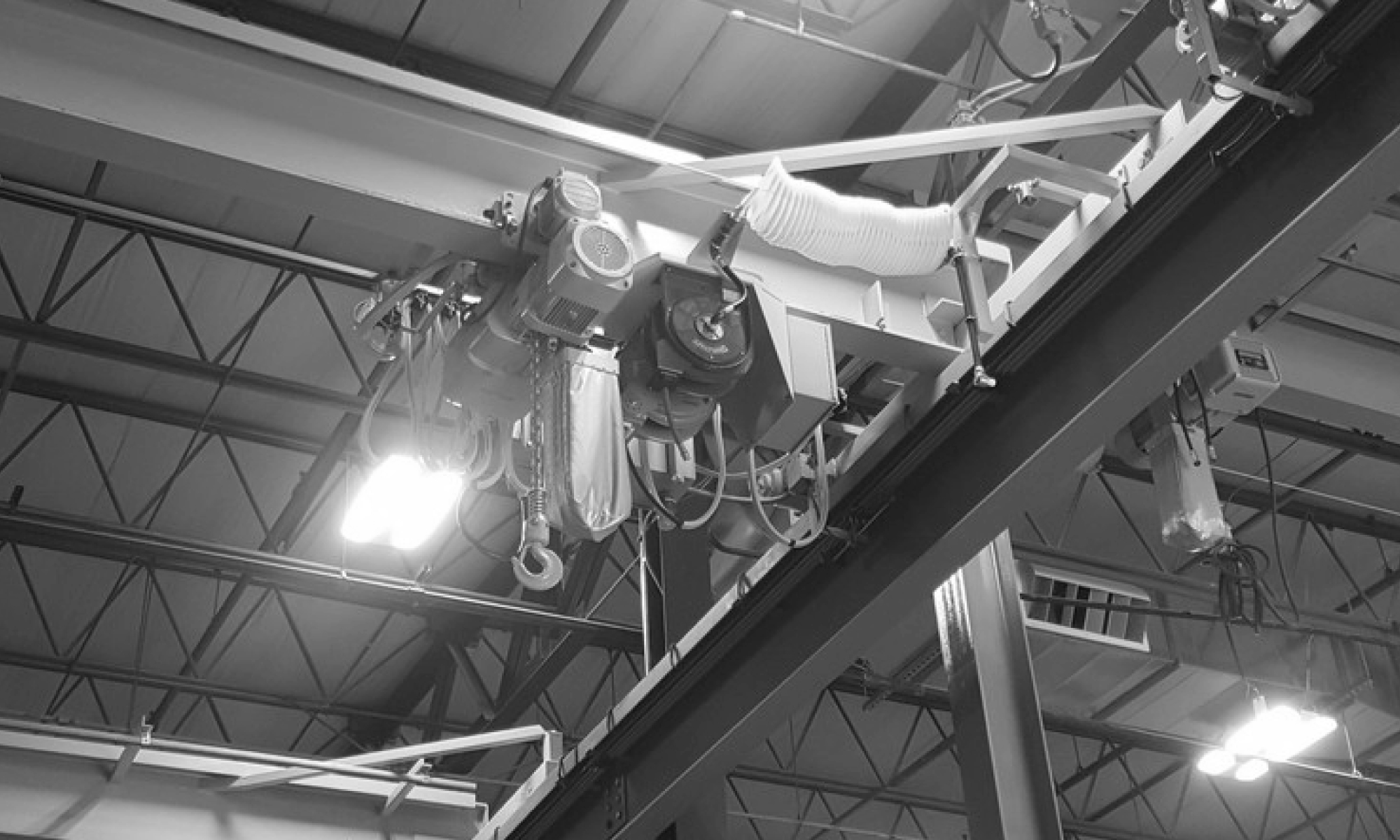 interior of a ware house with multiple yellow ceiling crane beams - Aero Material Handling Inc