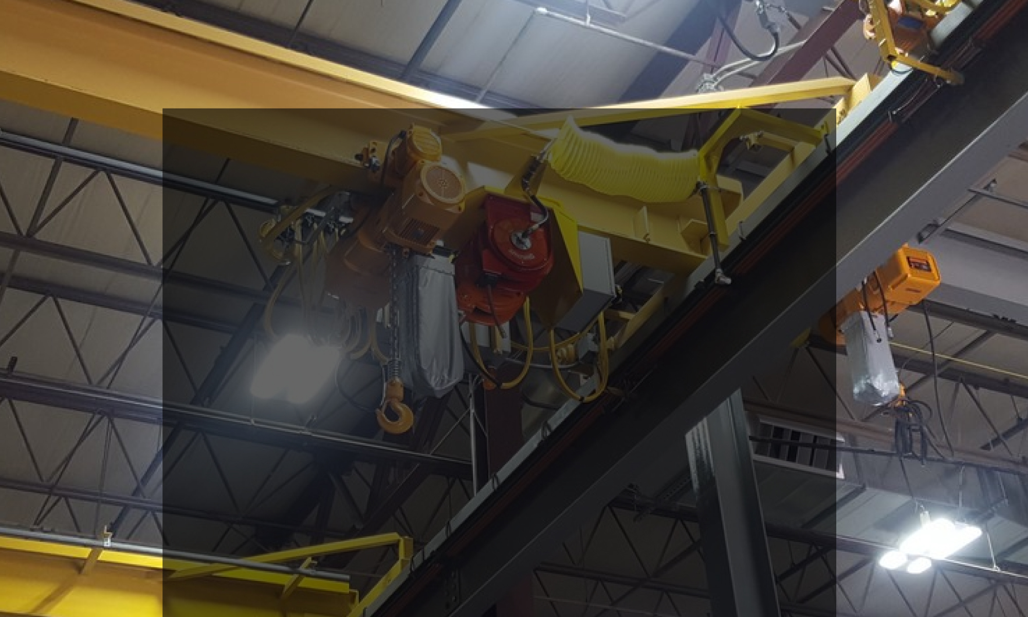 interior of a ware house with multiple yellow ceiling crane beams - Aero Material Handling Inc